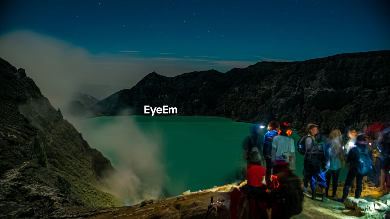 PANORAMIC VIEW OF PEOPLE ON MOUNTAIN AT NIGHT