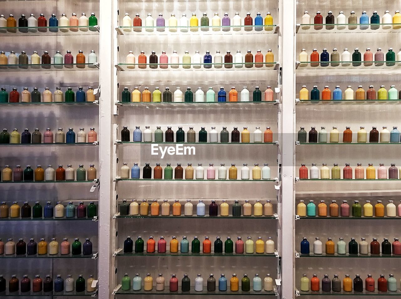 Full frame shot of colorful bottles on shelves for sale in store