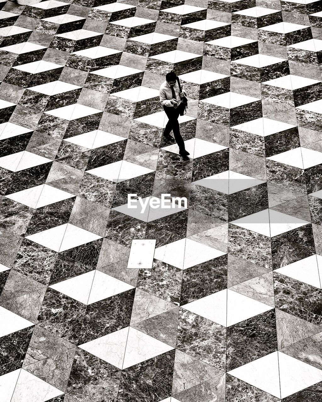 High angle view of man walking on tiled floor