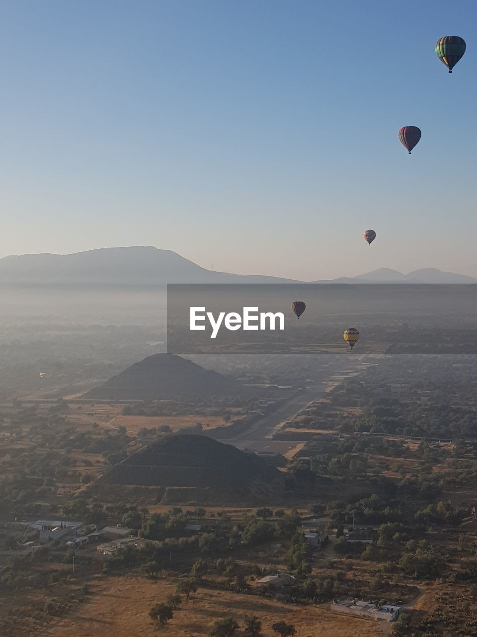 Scenic view of hot air balloons flying in sky