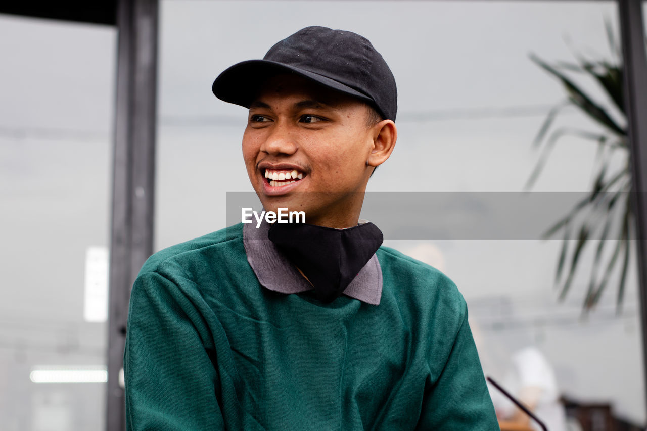 Portrait of a handsome man who looks happy. with a cool look using a hat and mask