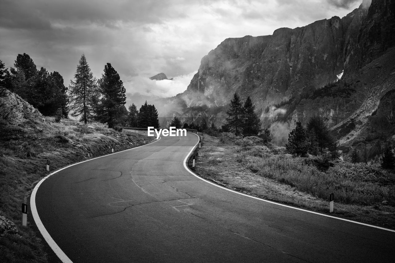 Road amidst trees against sky
