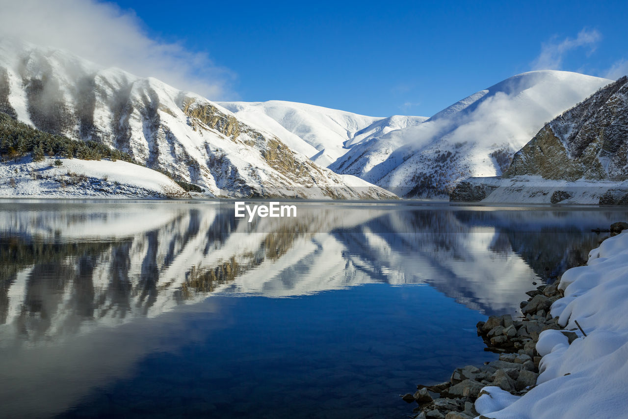 Beautiful mountain lake in winter. scenic view of lake and snowcapped mountains against sky