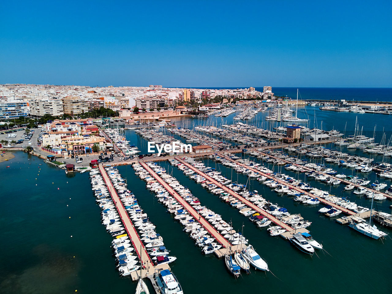 Aerial view of commercial dock against clear blue sky during sunny day