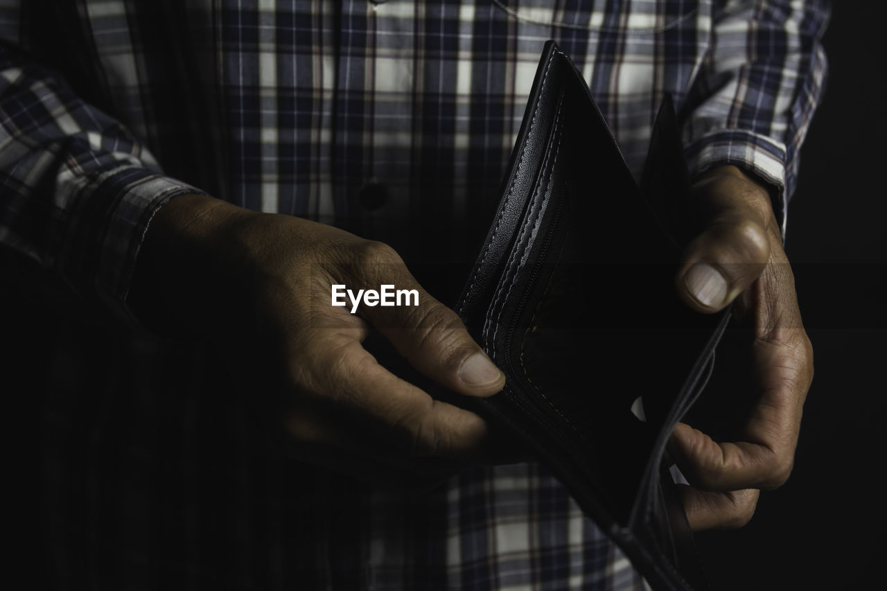 Midsection of man holding empty wallet