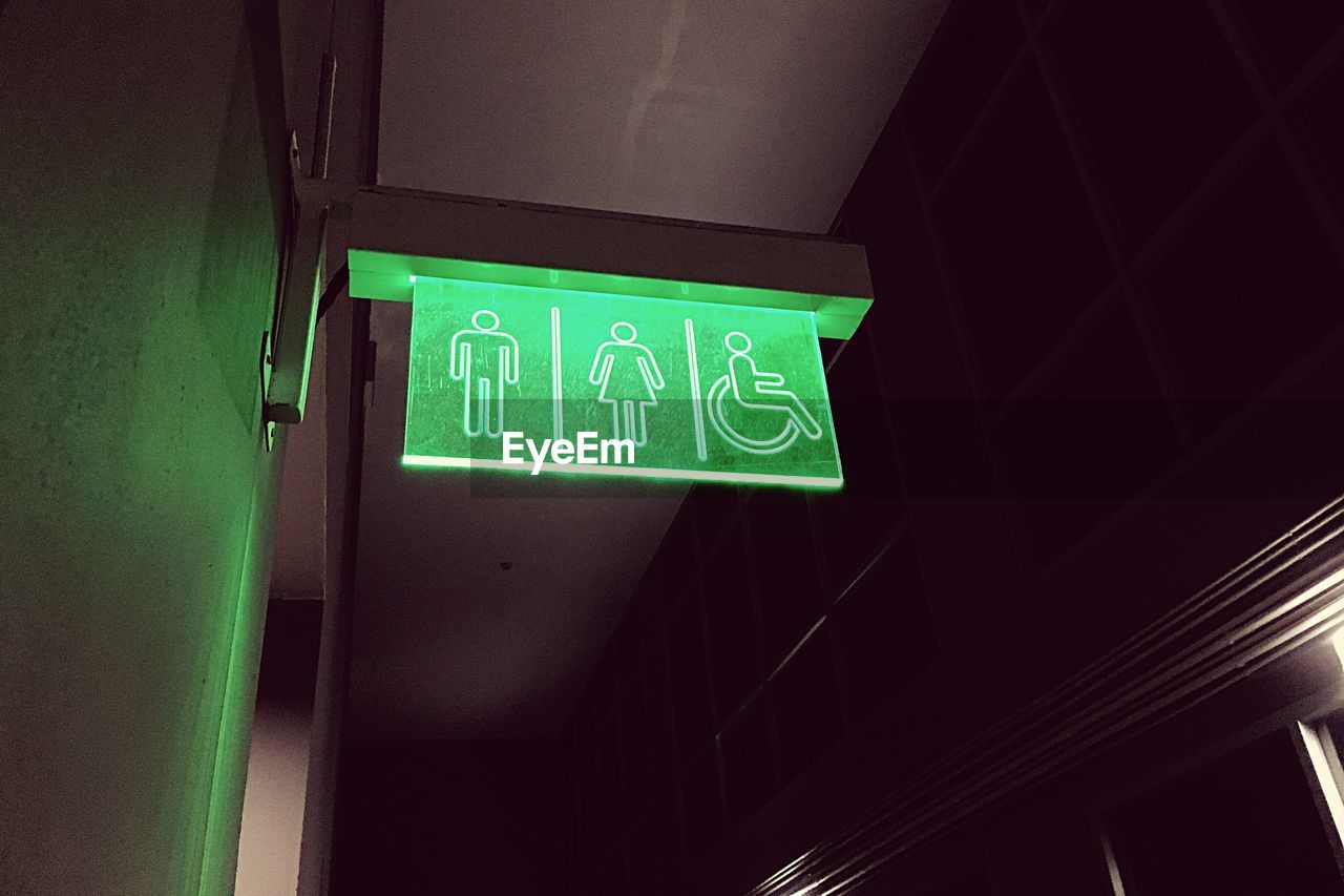 Low angle view of green restroom sign