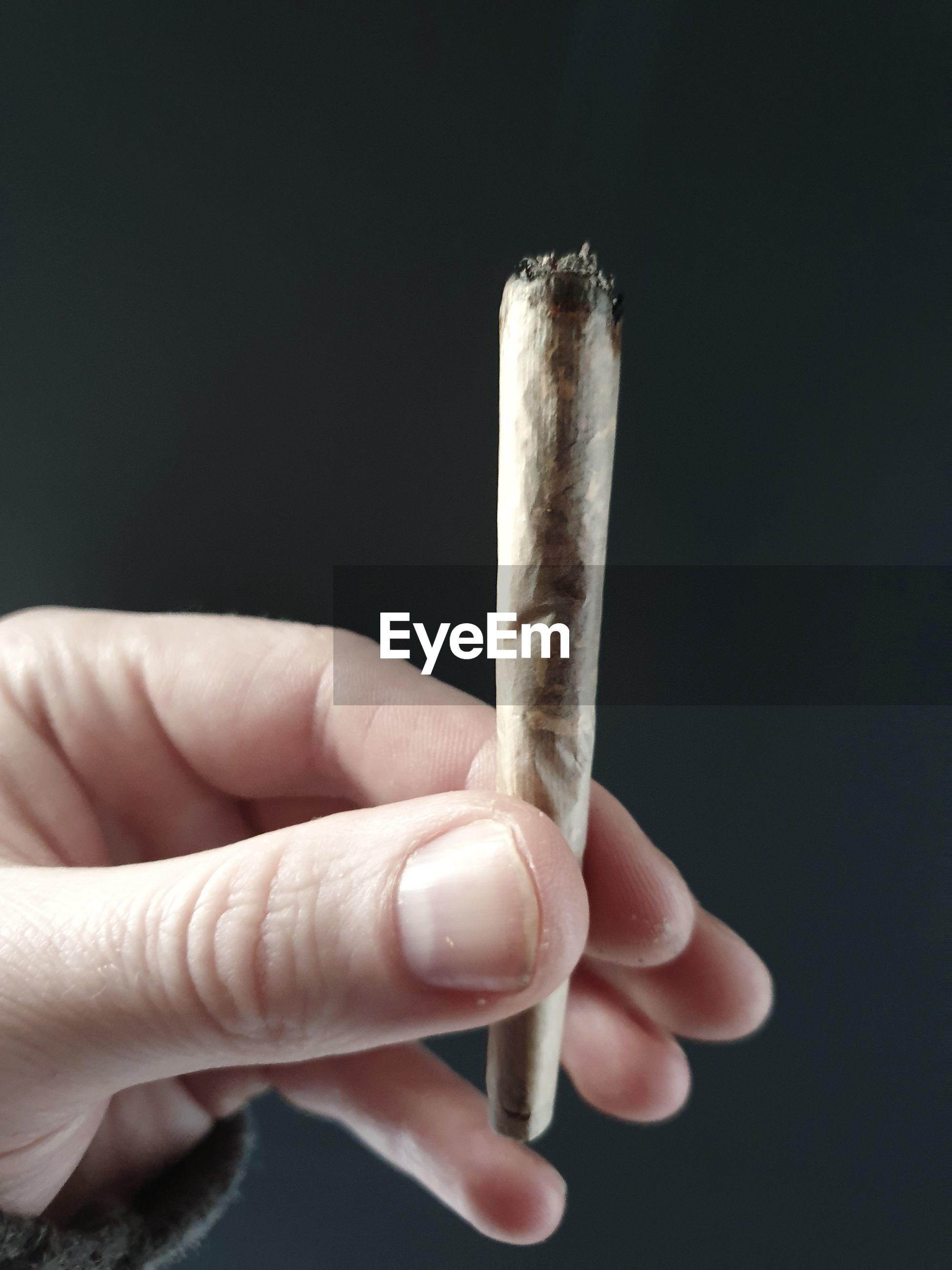 Closeup of hand holding joint against ID 138017540