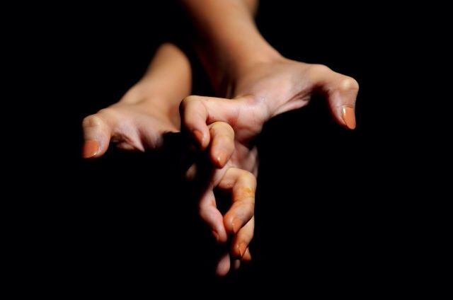 CROPPED IMAGE OF HAND HOLDING OVER BLACK BACKGROUND