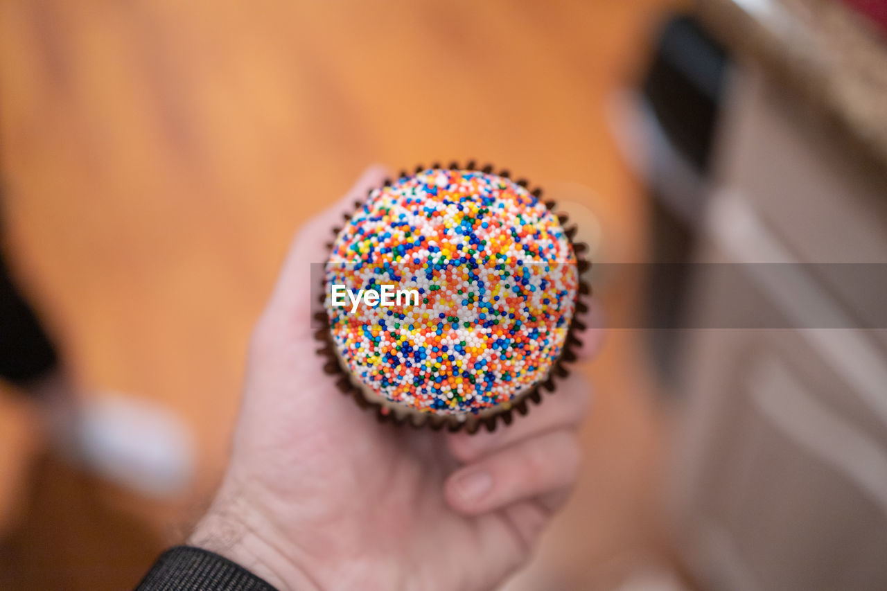Person holding birthday cake cupcake