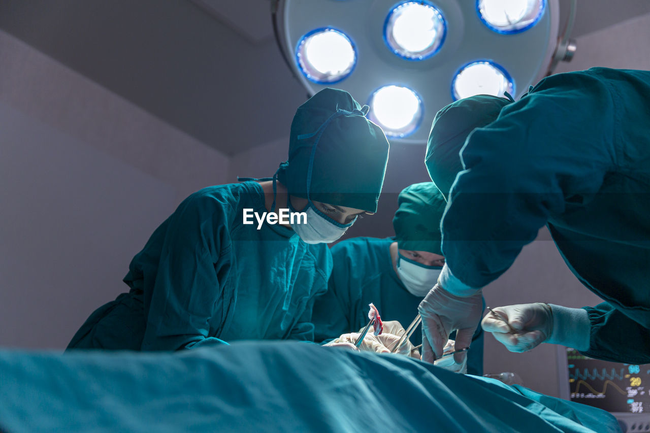 The surgeon team is working in the operating room. the surgeon is saving the patient's life.