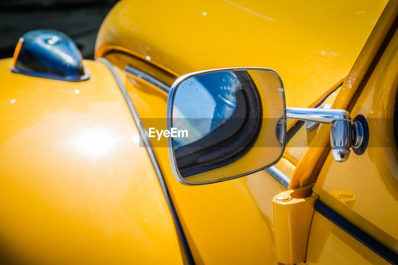 Close-up of side-view mirror of yellow car