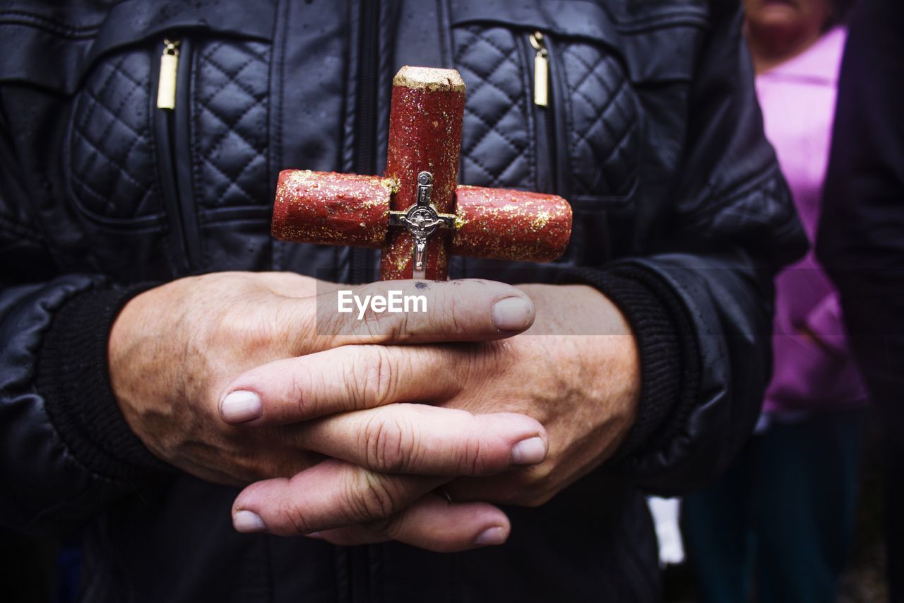 Close-up of man holding religious cross