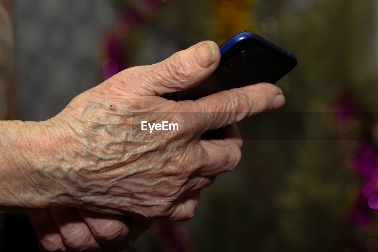 hand, senior adult, close-up, adult, one person, focus on foreground, holding, finger, arm, seniors, communication, technology, women, wrinkled, lifestyles, men