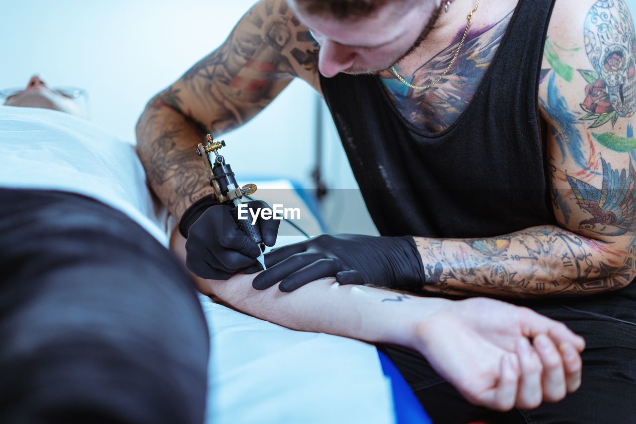 Man tattooing on customer hand