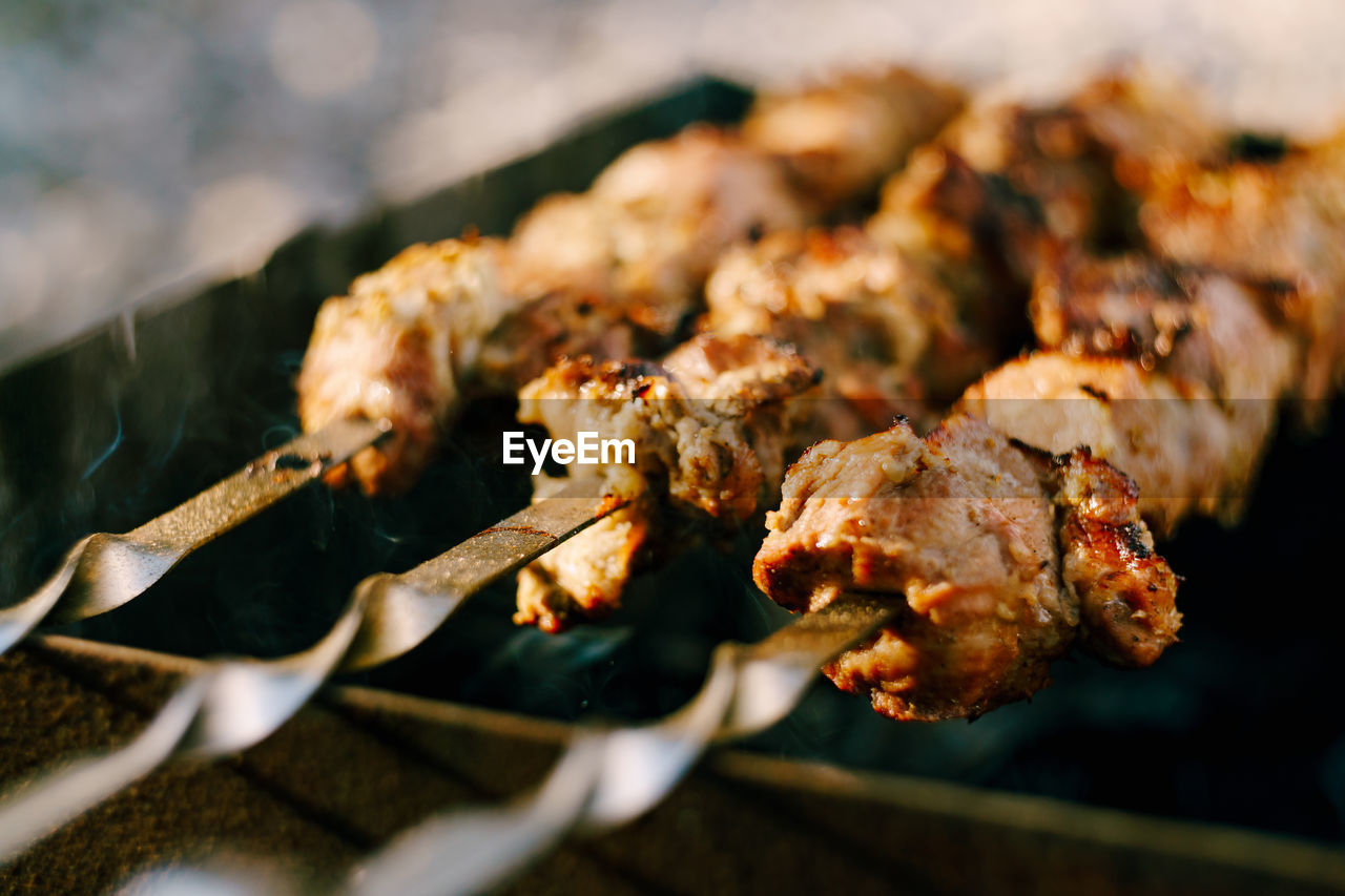 CLOSE-UP OF MEAT ON GRILL