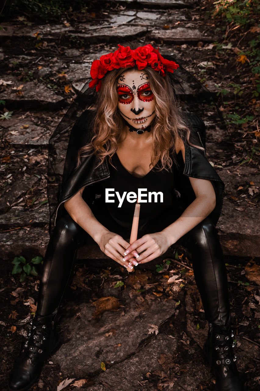Happy halloween concept. scared horrible female in special outfit, wears white clay skull