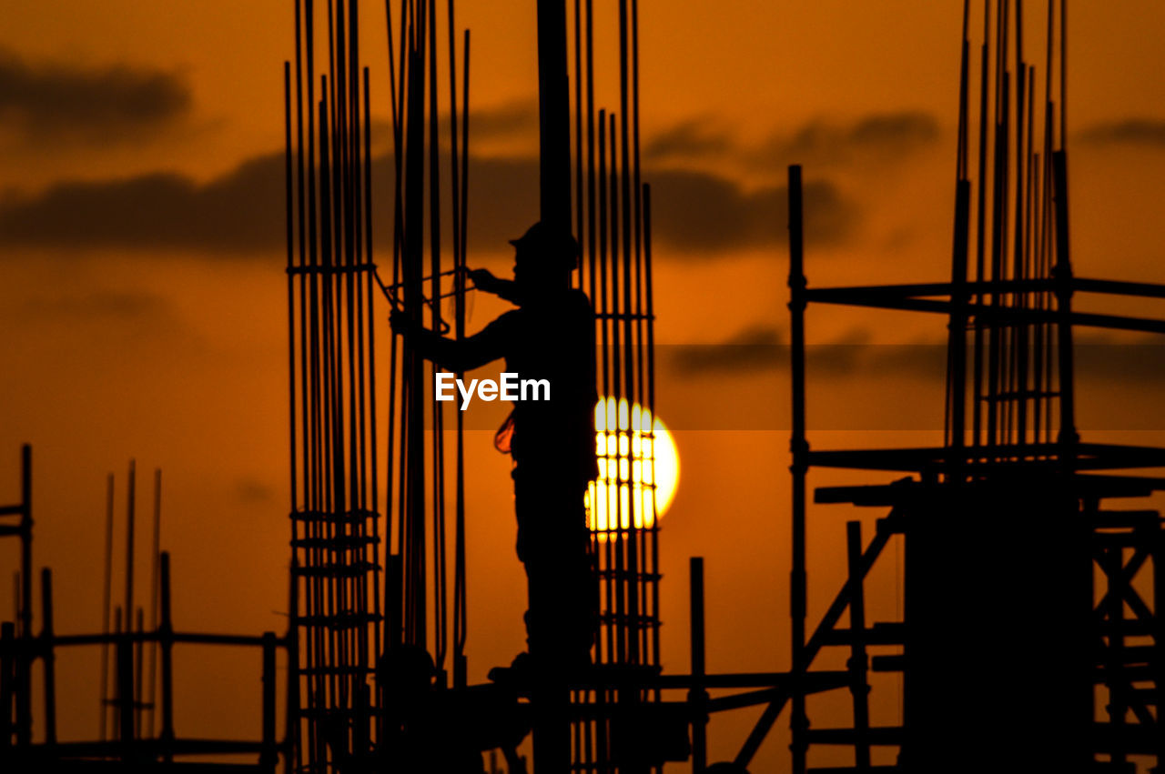 Silhouette of construction worker at sunset