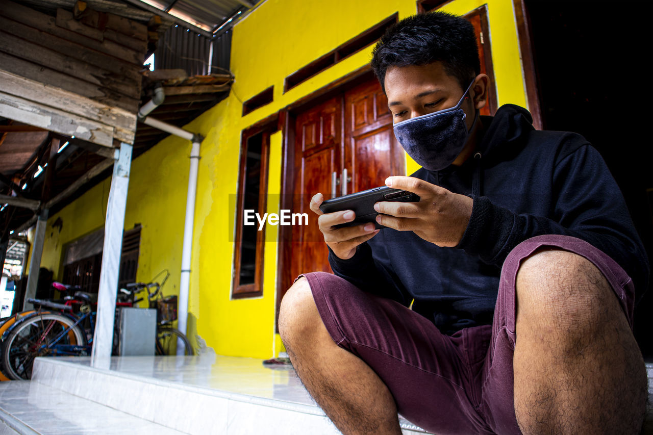 Full length of man using mobile phone