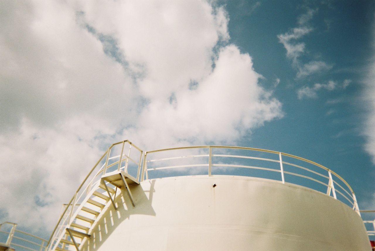Low angle view of oil industry against sky