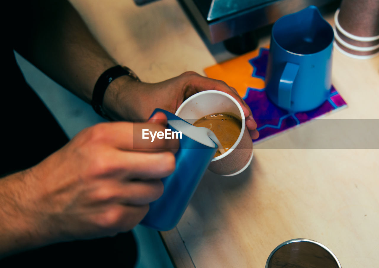 Cropped image of man preparing coffee at counter in cafe