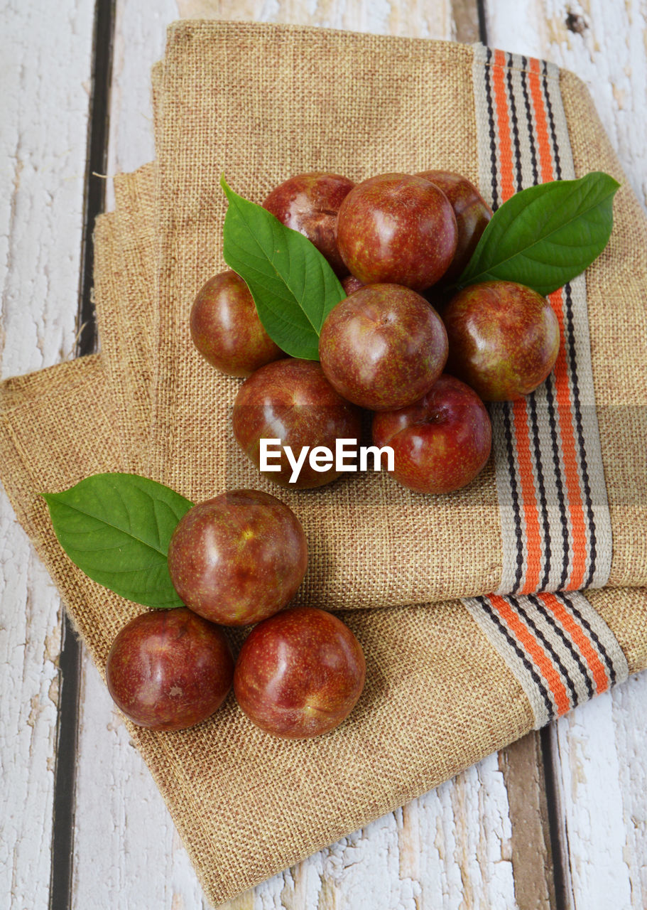 Shiny delicious fresh harvested asian plums under the sun