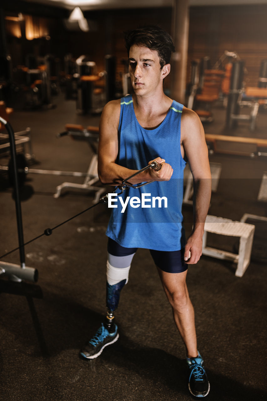 Man with artificial leg exercising in gym