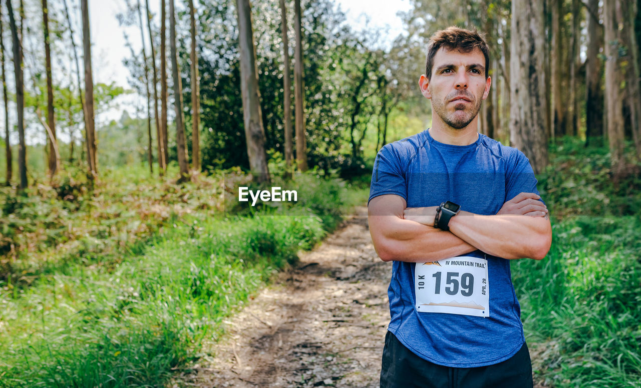Man standing with marathon bib in forest