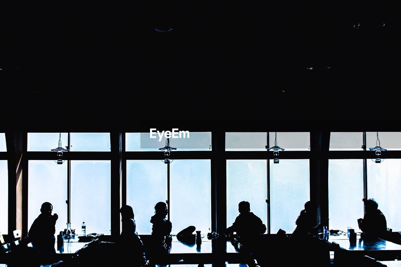 Silhouette people sitting at table in restaurant