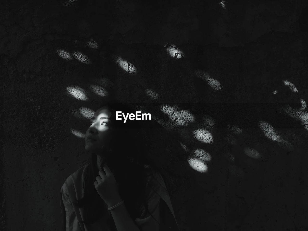 Woman with shadow against wall