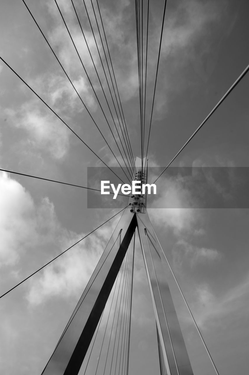 LOW ANGLE VIEW OF BRIDGE CABLES AGAINST CLOUDY SKY