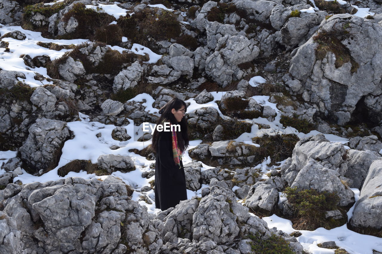 Woman standing on frozen rock
