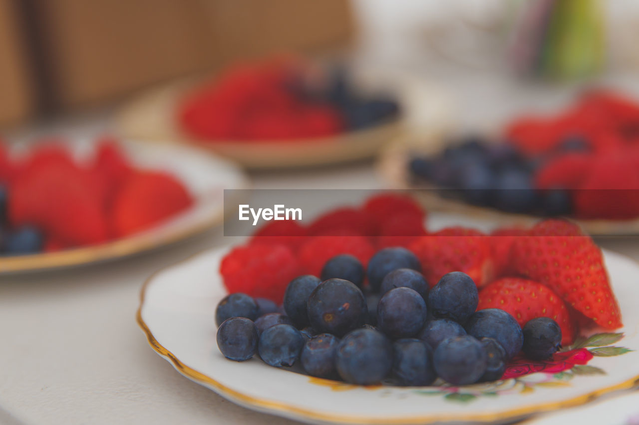 Close-up of strawberries and blueberries in plate on table