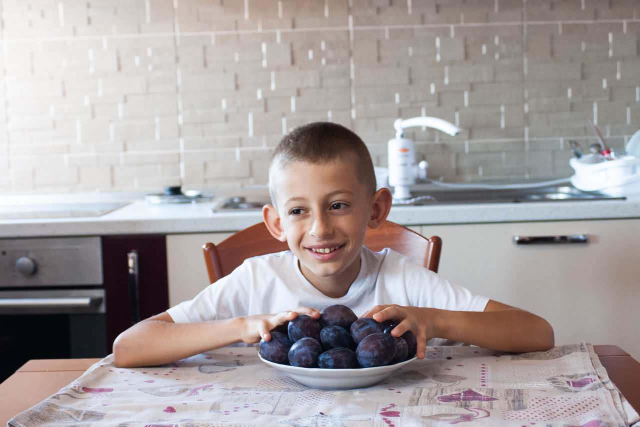 Portrait of happy boy with fruits