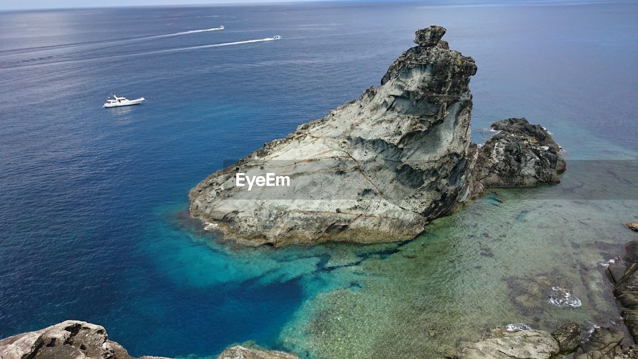 HIGH ANGLE VIEW OF ROCK IN SEA