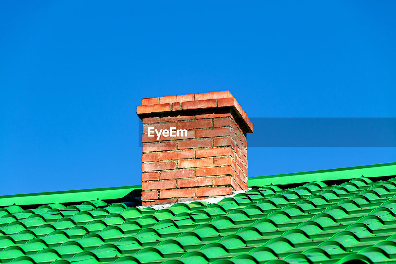 architecture, built structure, blue, sky, clear sky, building exterior, building, no people, brick, roof tile, nature, roof, copy space, house, day, low angle view, outdoors, brick wall, sunny, wall, green, wall - building feature