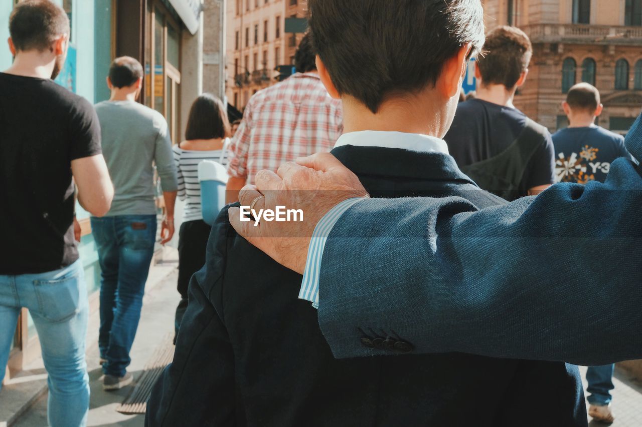 Rear view of people standing in city