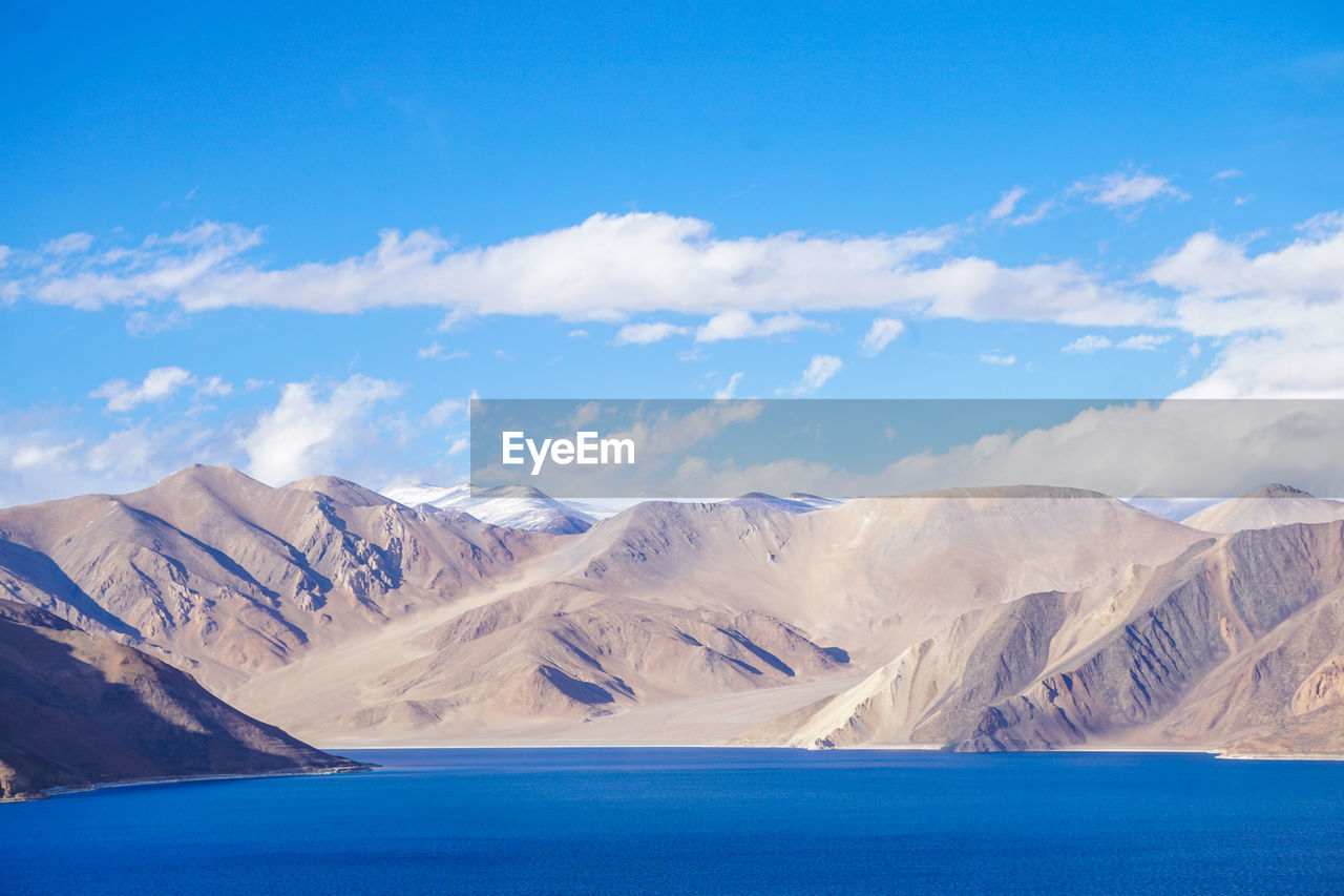 Scenic view of snowcapped mountains against blue sky