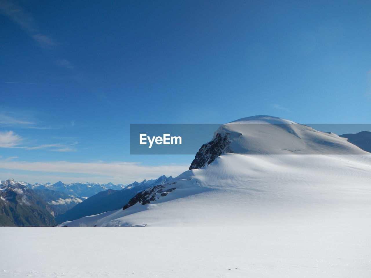 Scenic view of snow mountains against blue sky