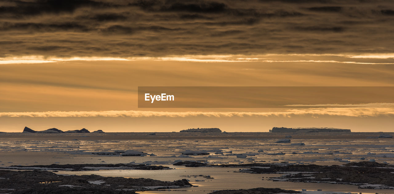 SCENIC VIEW OF SEA AGAINST ORANGE SKY