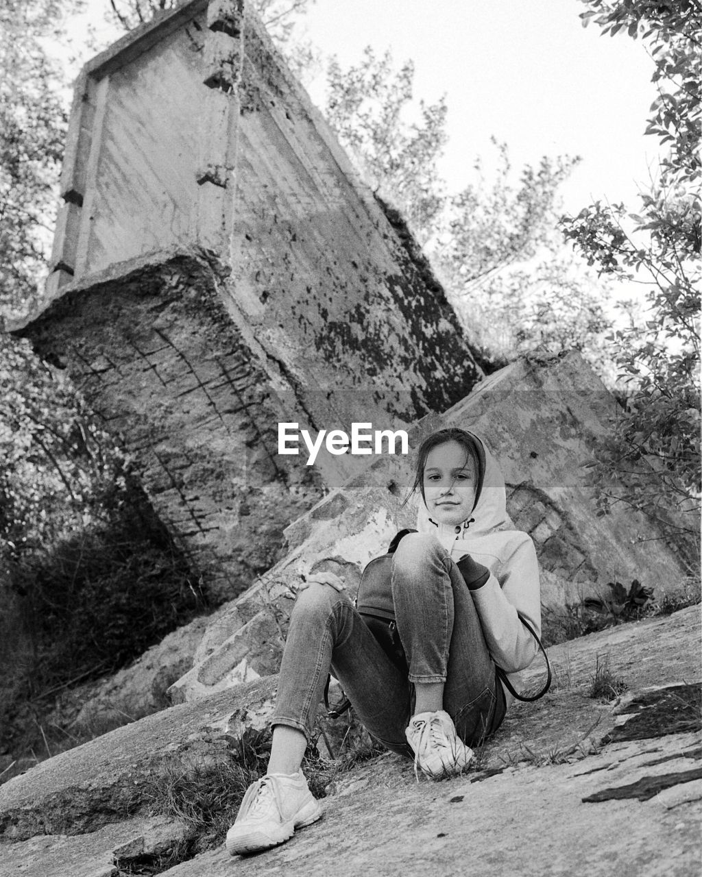 Portrait of girl sitting on rock