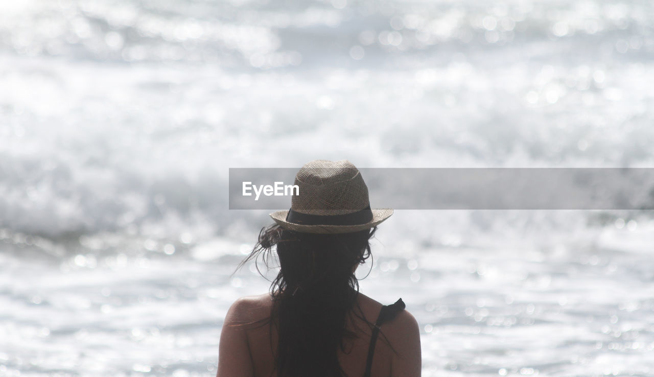 Rear view of woman wearing hat against sea