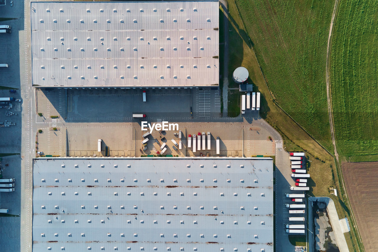 Factory warehouse with parked semi trucks, aerial view