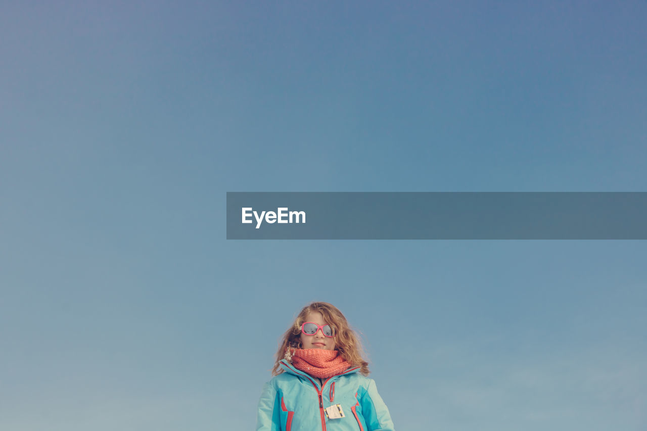 Portrait of girl against blue sky