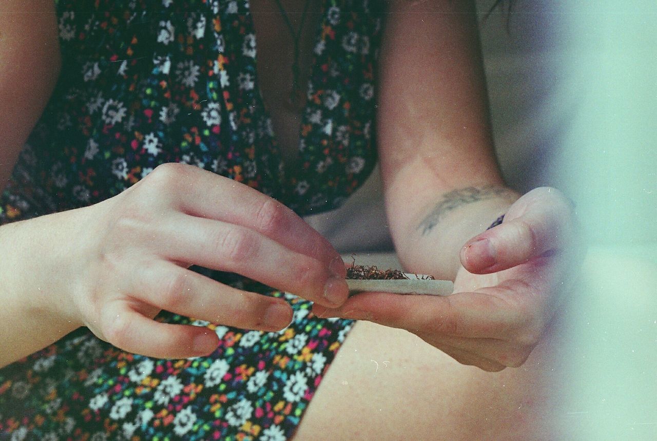 Midsection of woman holding marijuana joint