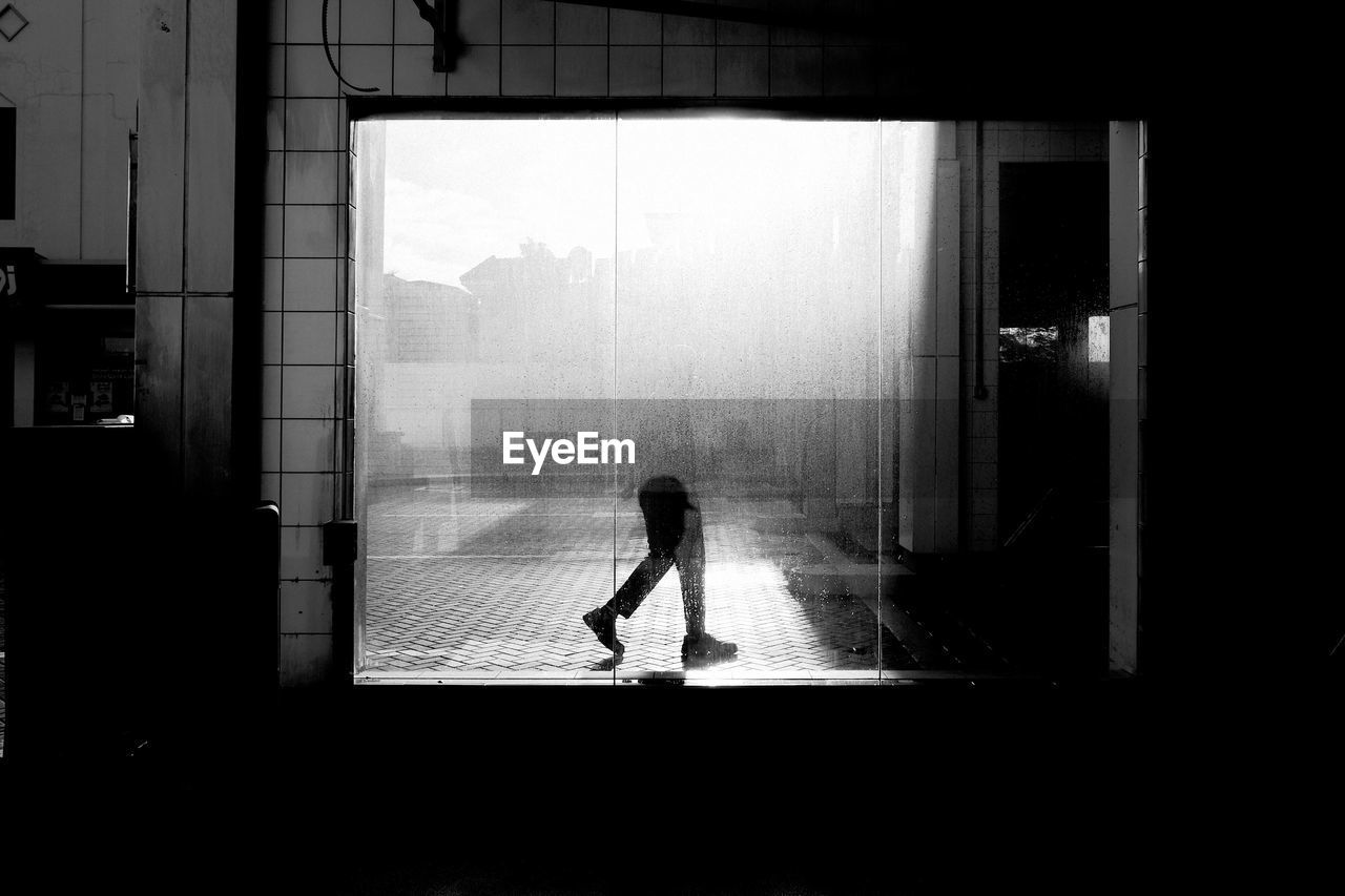 Person seen through wet window during rainy season