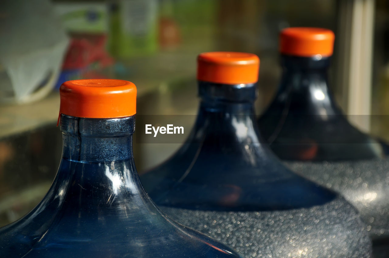 bottle, container, glass, blue, food and drink, close-up, no people, focus on foreground, drinkware, refreshment, alcohol, indoors, drink, alcoholic beverage, red, household equipment, in a row, still life photography