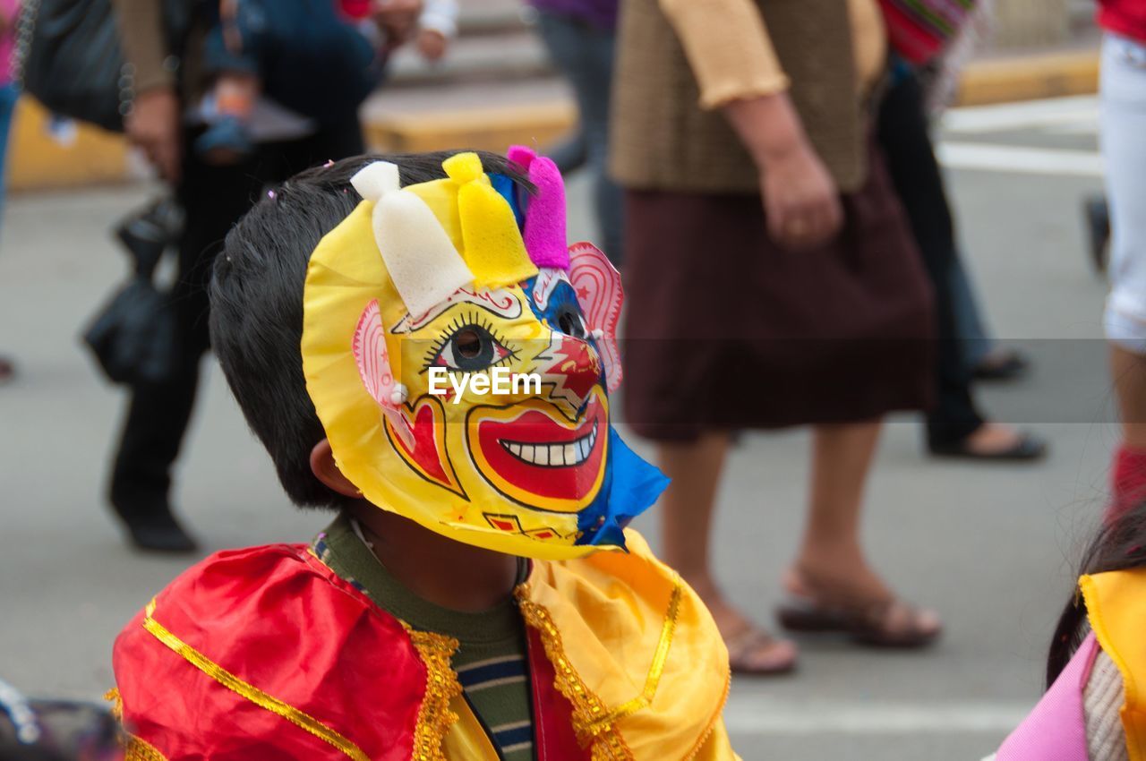 Close-up of boy wearing costume while standing on road in city