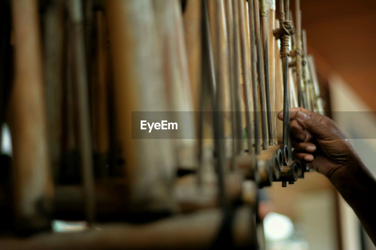 Cropped hand of person touching musical instrument indoors