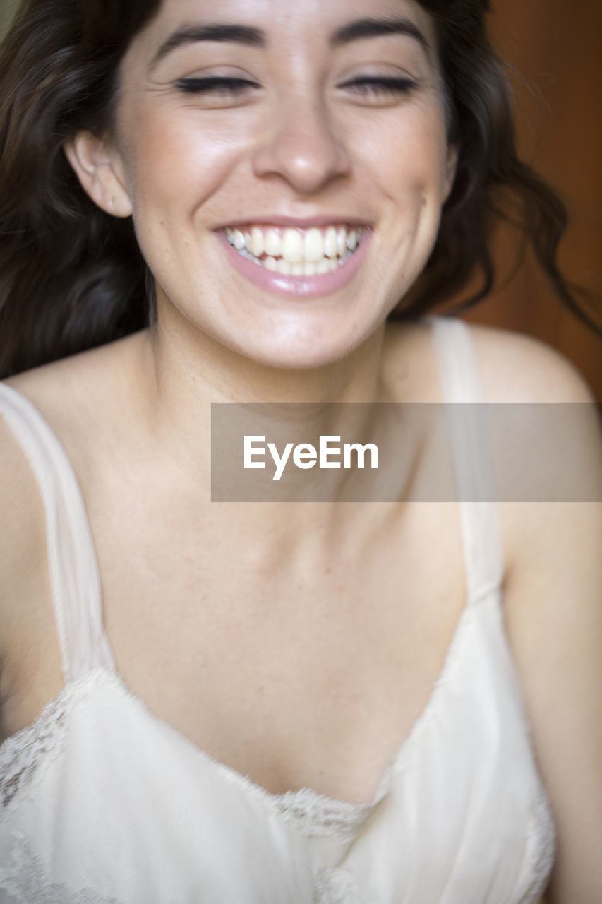 Close-up of cheerful young woman standing at home