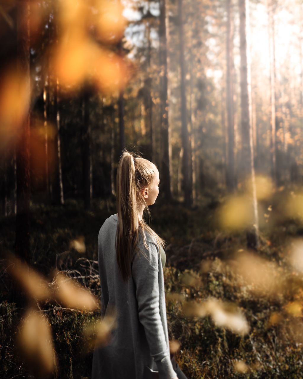 Rear view of young woman standing in forest